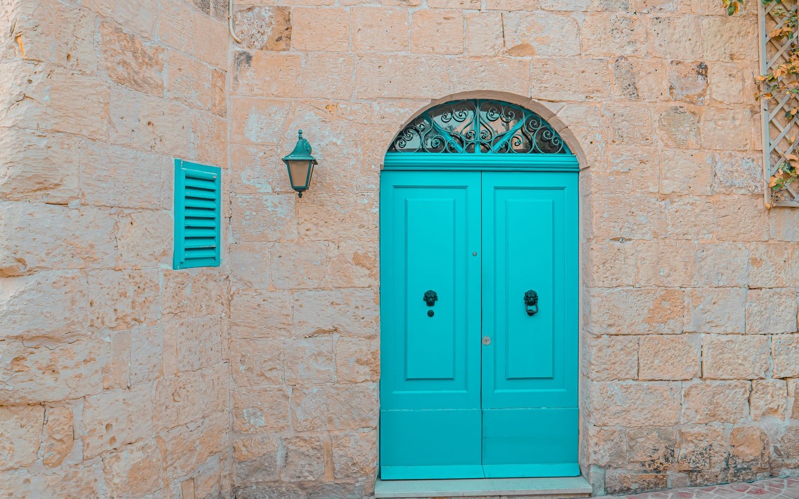 A printed DPE energy performance certificate pinned beside a rough-cut limestone doorway, the G band circled in red