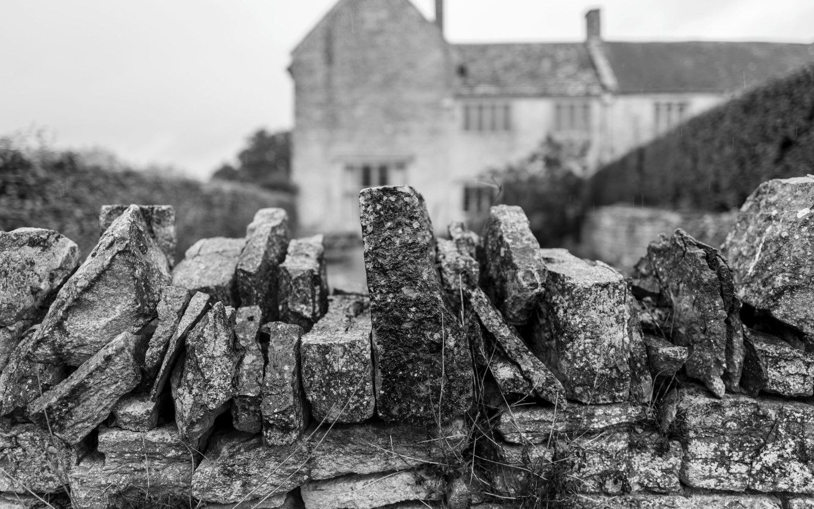 An adult drystone waller's hands setting a course of dressed limestone, Causses plateau