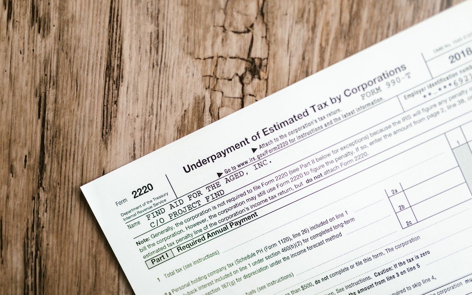 IRS Form 2220 for underpayment of estimated tax by corporations on wooden table