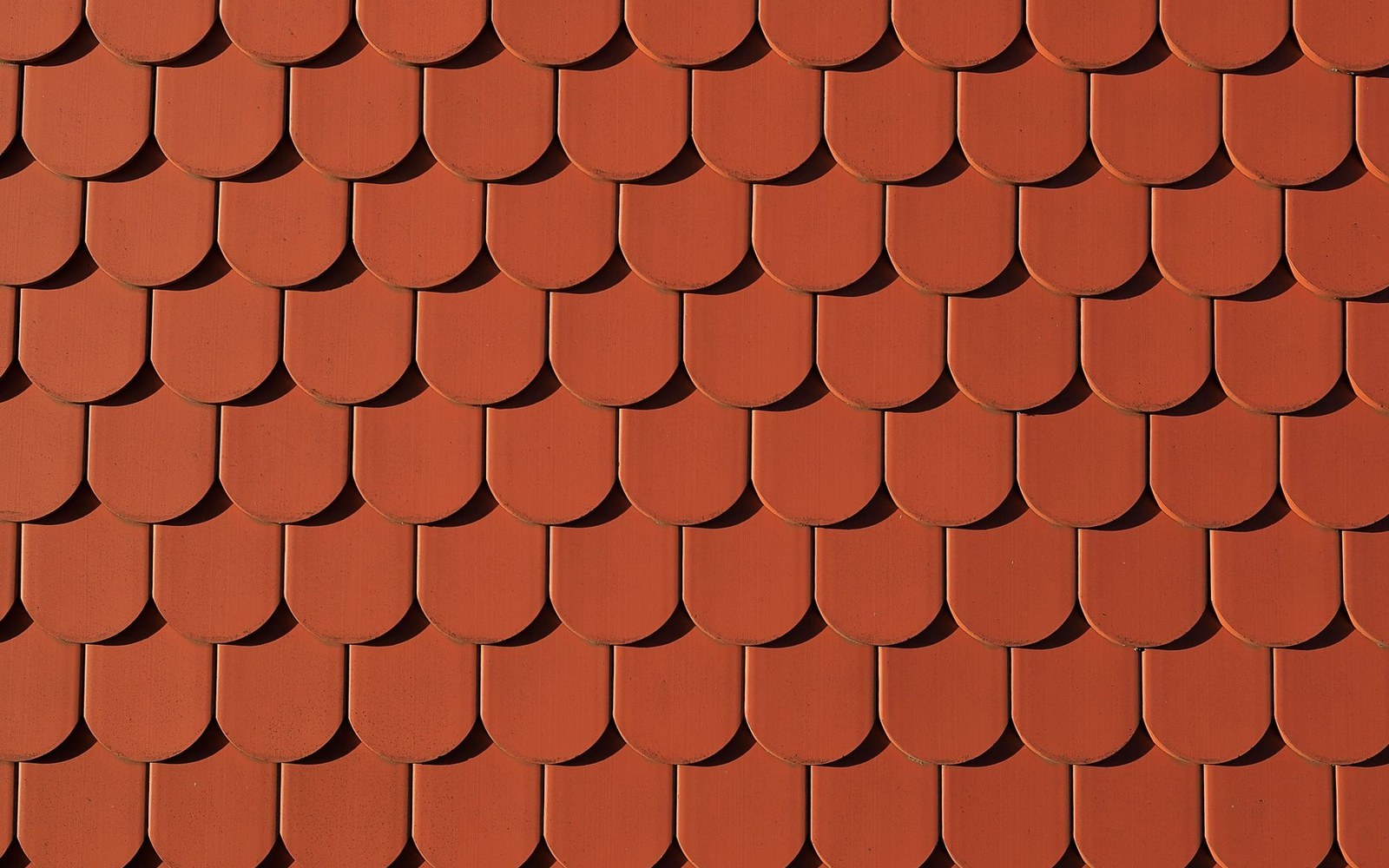 Rows of overlapping curved terracotta roof tiles arranged in a scalloped pattern
